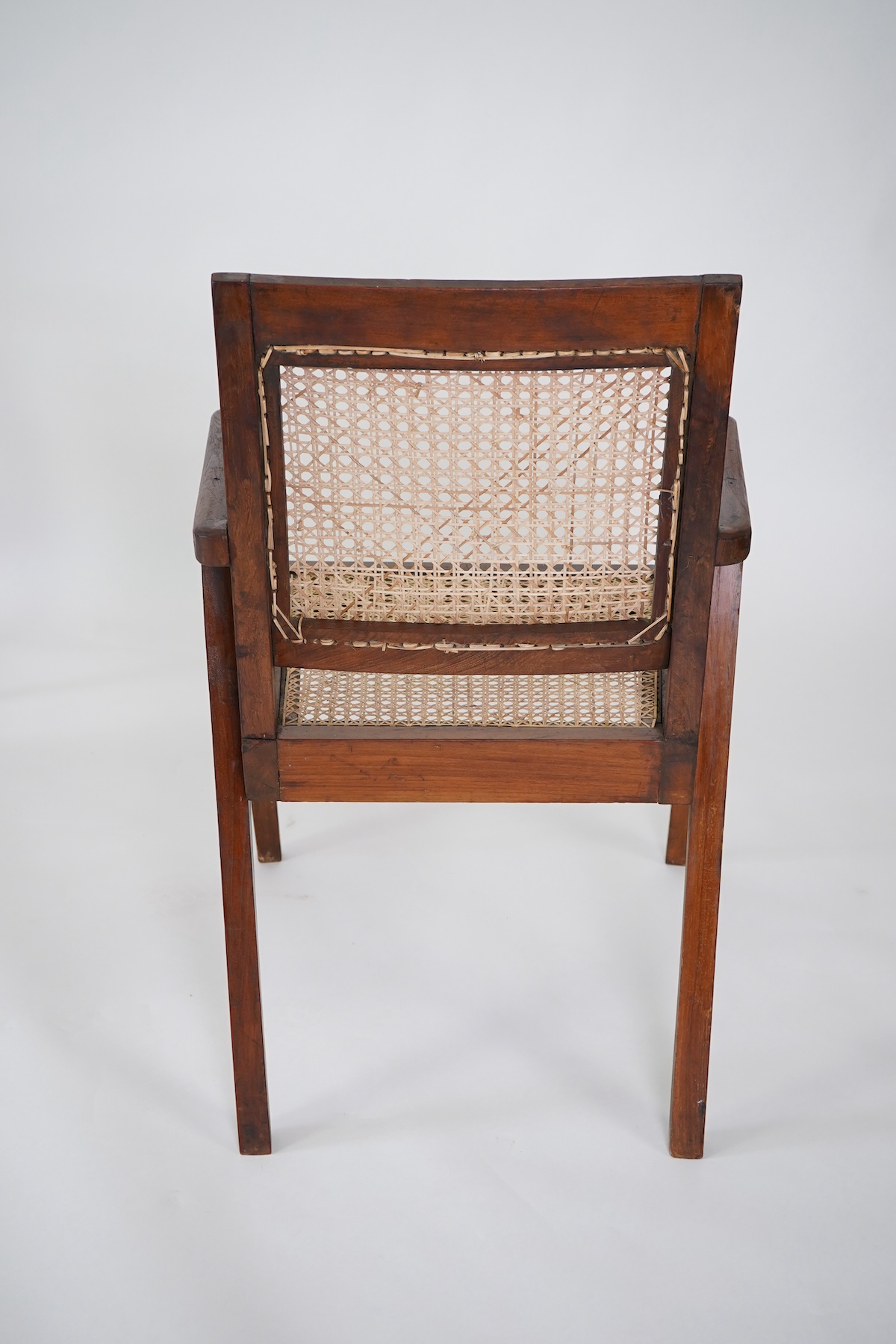 Manner of Pierre Jeanneret (Swiss, 1896-1967): A set of four solid teak and braided canework armchairs